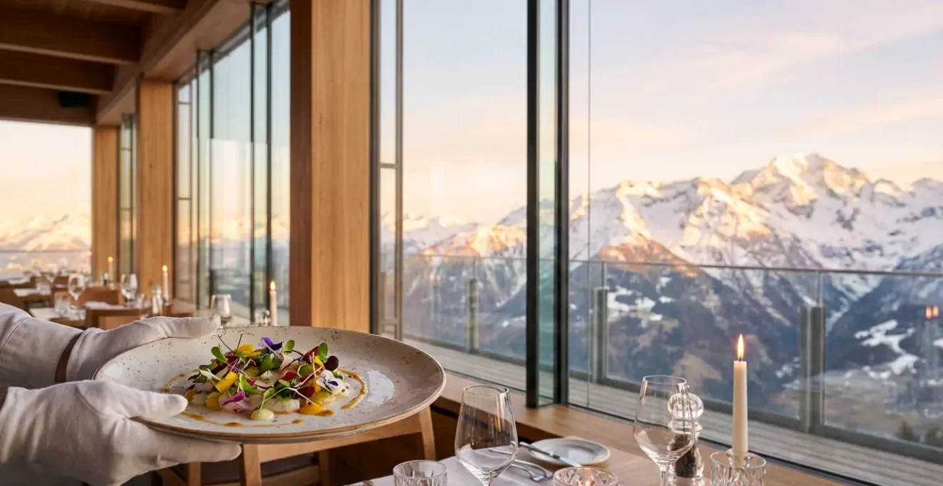 Service d'un plat gastronomique dans un restaurant étoilé avec vue panoramique sur les sommets enneigés